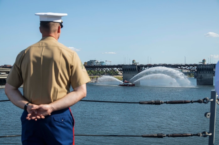 PORTLAND, OREGON (June 3, 2025) – U.S. Marine Corps Cpl. Kanon Cole a meteorology and oceanography forecaster Battel Space Surveillance Company, 1st Intelligence Battalion, I Marine Expeditionary Force Information Group, and a native of Vermont, mans the rails of the Arleigh Burke-class guided missile destroyer USS Mustin (DDG 89) sailing in the Willamette River as it arrives for Portland Fleet Week during the 118th Rose Festival, June 3, 2025. Portland Fleet Week is a time-honored celebration of the sea services and provides an opportunity for the citizens of Oregon to meet Sailors, Marines, and Coast Guardsmen, as well as witness firsthand the latest capabilities of today’s maritime services. (U.S. Marine Corps photo by Sgt. Amelia Kang)
