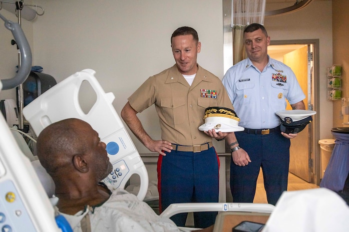 PORTLAND, OREGON (June 5, 2025) – U.S. Marine Corps Lt. Col. Robert Reagles, center, commanding officer for 1st Intelligence Battalion, I Marine Expeditionary Unit Information Group, and U.S. Coast Guard Command Master Chief Mike Demopoulos, right, Reserve Command Master Chief 13th District, visits with a Marine Corps veteran at the Portland VA Medical Center during Portland Fleet Week, June 5, 2025. Portland Fleet Week is a time-honored celebration of the sea services and provides an opportunity for the citizens of Oregon to meet Sailors, Marines, and Coast Guardsmen, as well as witness firsthand the latest capabilities of today’s maritime services. (U.S. Marine Corps photo by Sgt. Amelia Kang)