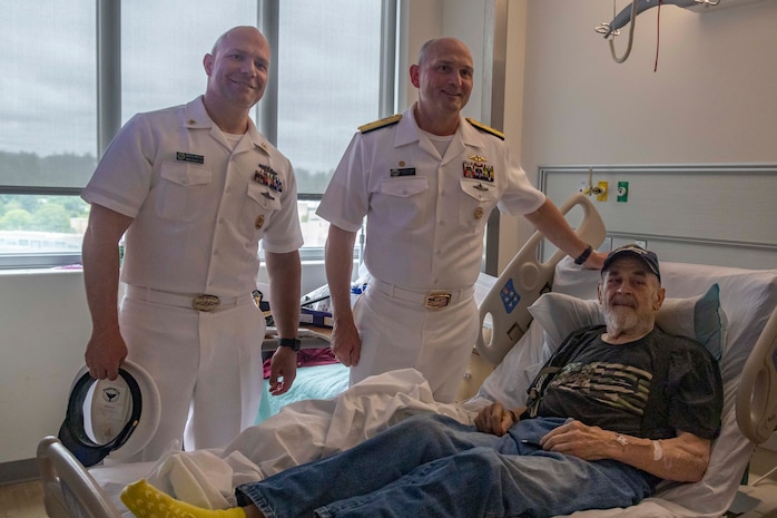 PORTLAND, OREGON (June 5, 2025) – U.S. Navy Rear Adm. Christopher Nash, center, commander, Submarine Group 9, and Command Master Chief Travis Brown, left, Command Master Chief of Navy Region Northwest,  pose for a photo with a Navy veteran at the Portland VA Medical Center during Portland Fleet Week, June 5, 2025. Portland Fleet Week is a time-honored celebration of the sea services and provides an opportunity for the citizens of Oregon to meet Sailors, Marines, and Coast Guardsmen, as well as witness firsthand the latest capabilities of today’s maritime services. (U.S. Marine Corps photo by Sgt. Amelia Kang)