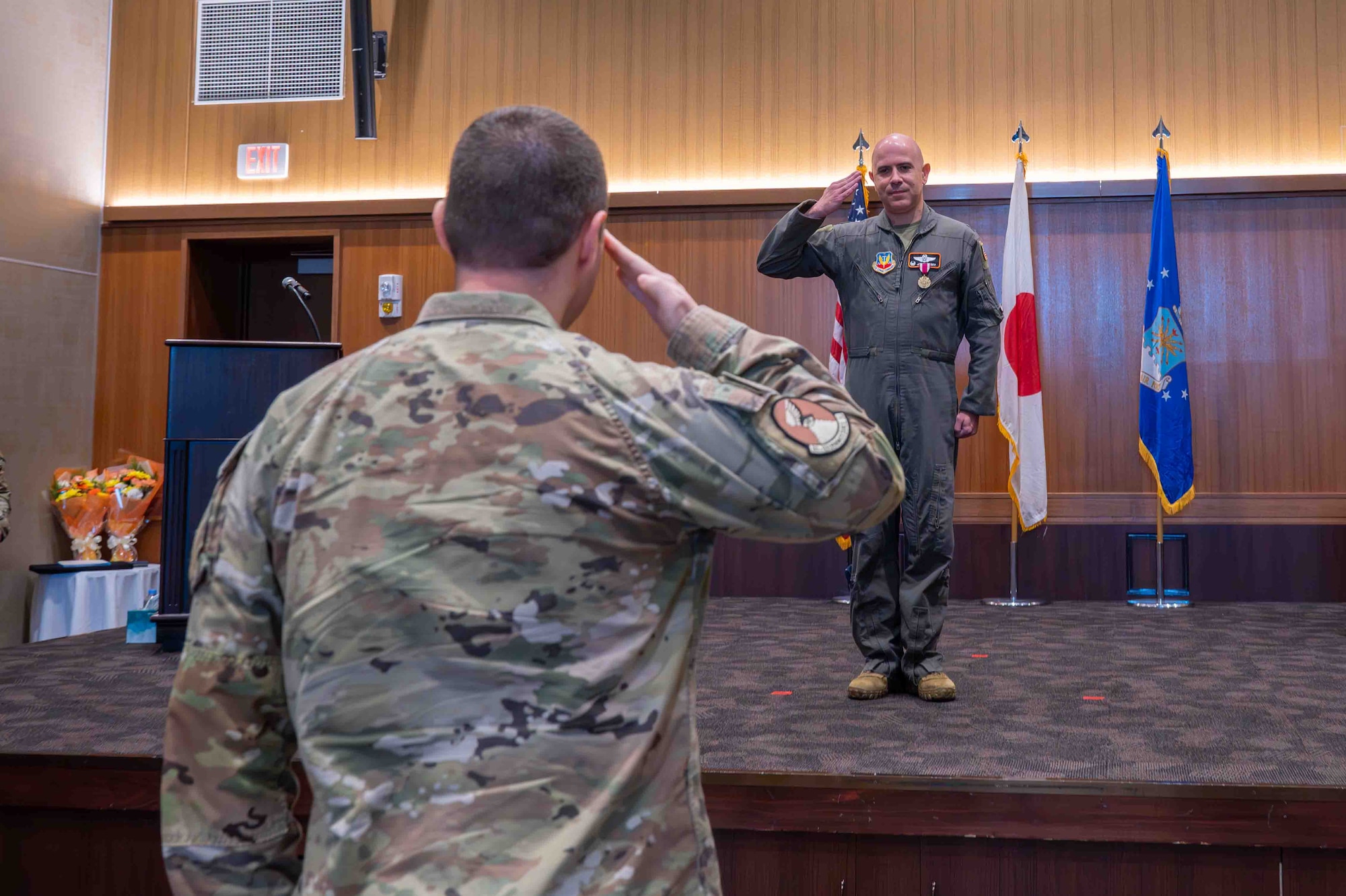 Two service members salute each other.