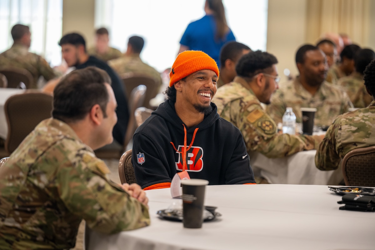 Brayln Lux, Cincinnati Bengals rookie, laughs with Airmen during lunch.