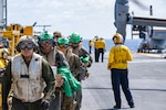 Marines assigned to the 31st Marine Expeditionary Unit (MEU) depart an MV-22B Osprey tiltrotor aircraft on the flight deck of the forward-deployed amphibious assault ship USS America (LHA 6) while conducting flight operations in the Philippine Sea, May 27.