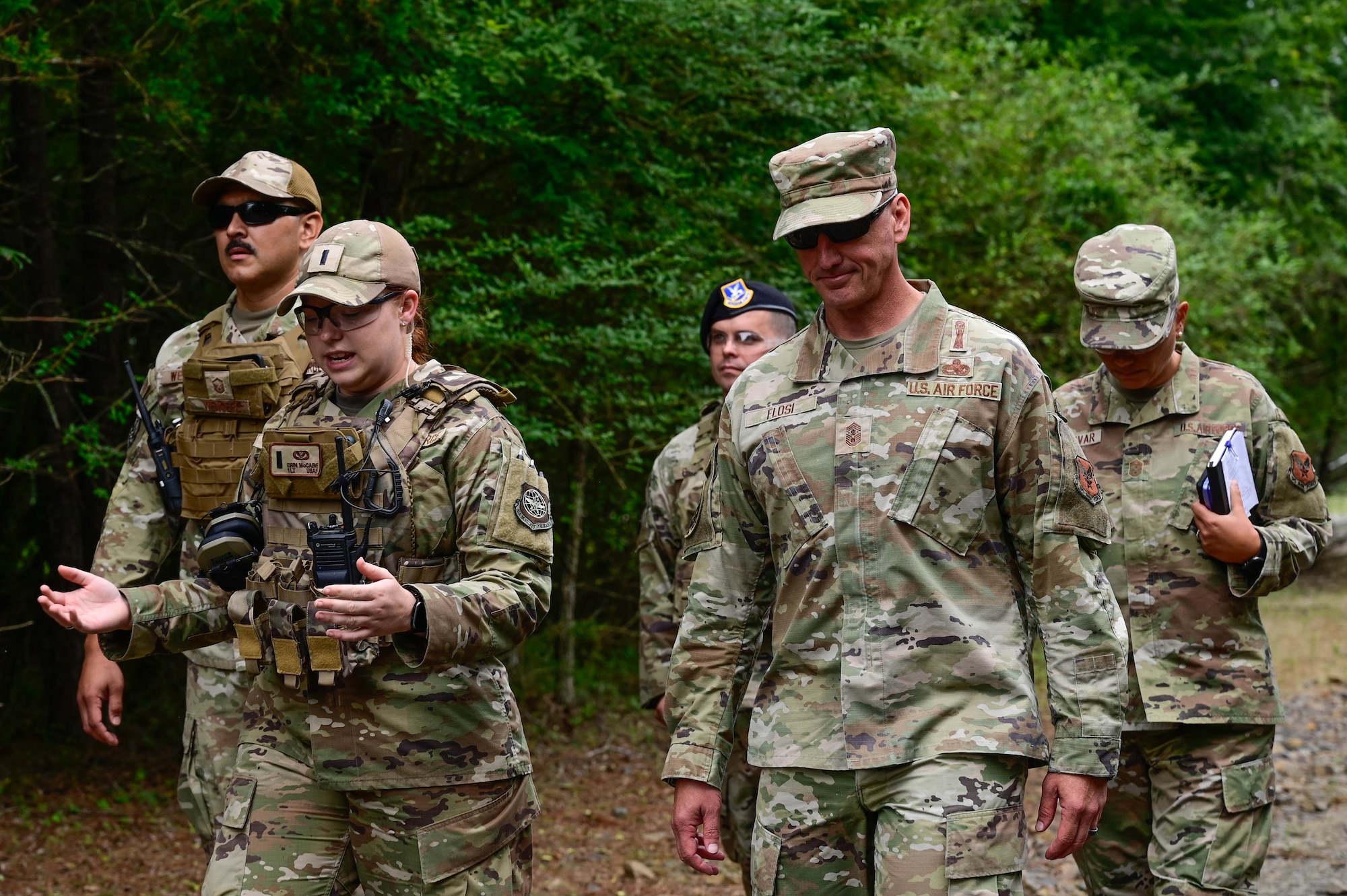 A group of people walk through a forest.