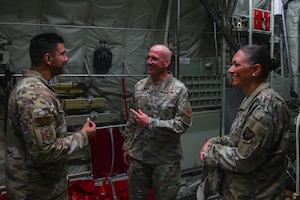 Service members talk in the back of an aircraft.