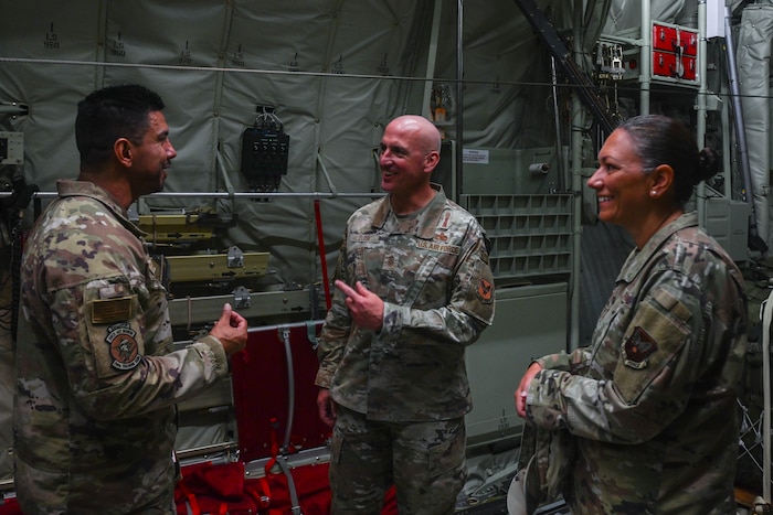 Service members talk in the back of an aircraft.
