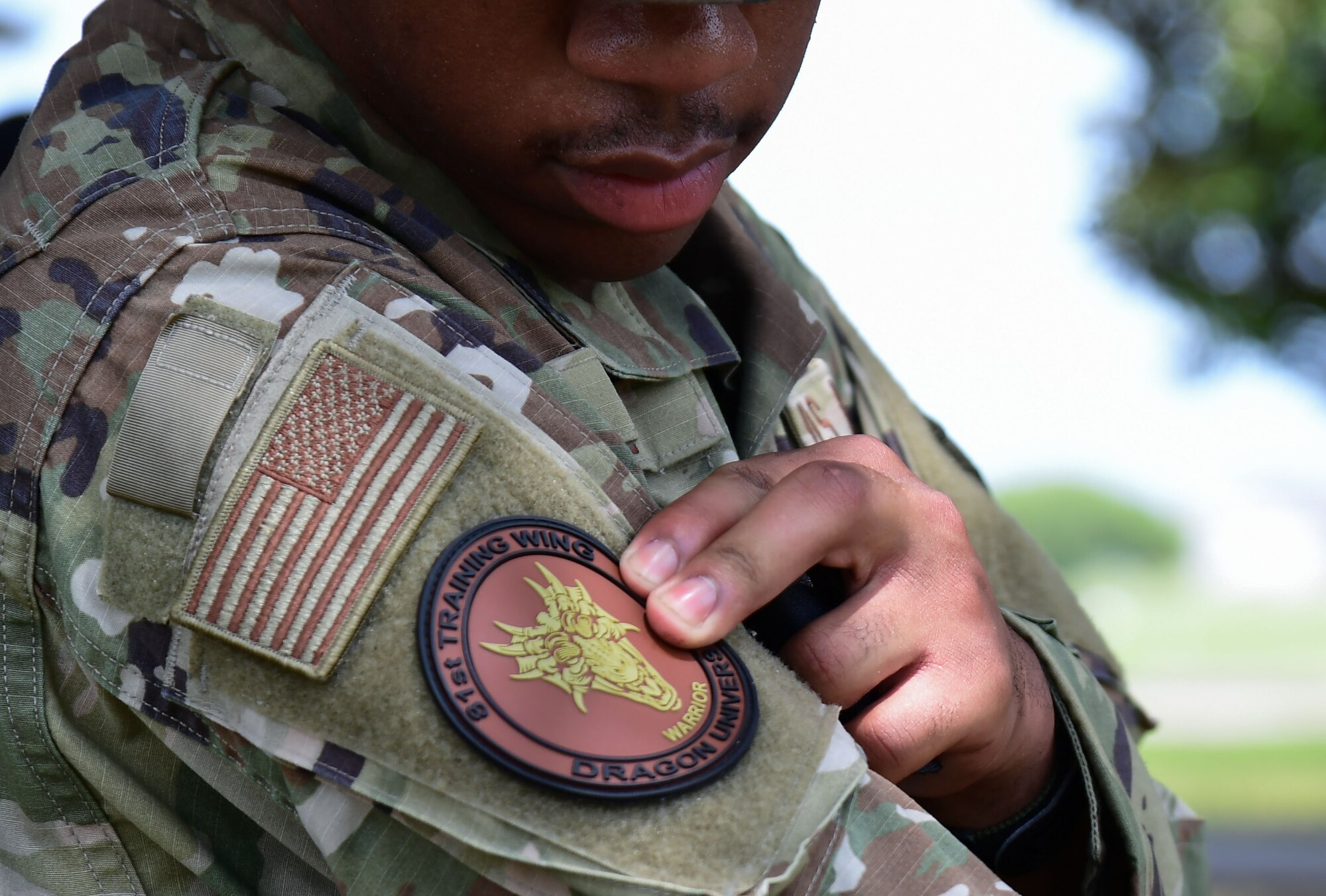 81st Logistics Readiness Squadron vehicle maintenance technician, secures a patch to his uniform after completing Warrior Day
