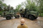 U.S. Marines with 8th Engineer Support Battalion, Combat Logistics Regiment 27, 2nd Marine Logistics Group, U.S. Navy Sailors assigned to Naval Construction Battalion (NCB) 14 and Latvian service members with Kurzemes 4th Brigade Engineering Unit clear debris in preparation for a portable boat ramp installation during exercise Baltic Operations 2025 (BALTOPS 25), June 9, 2025, in Liepaja, Latvia.