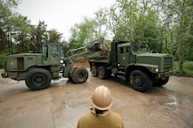 U.S. Marines with 8th Engineer Support Battalion, Combat Logistics Regiment 27, 2nd Marine Logistics Group, U.S. Navy Sailors assigned to Naval Construction Battalion (NCB) 14 and Latvian service members with Kurzemes 4th Brigade Engineering Unit clear debris in preparation for a portable boat ramp installation during exercise Baltic Operations 2025 (BALTOPS 25), June 9, 2025, in Liepaja, Latvia.