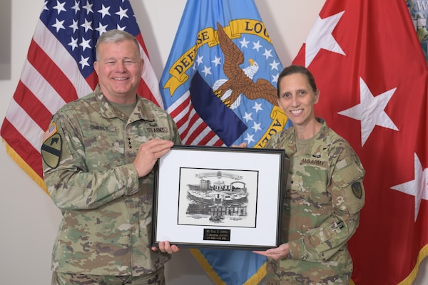 Defense Logistics Agency Director Army Lt. Gen. Mark Simerly, left, presents U.S. Army Materiel Command Chief of Operations Brig. Gen. Gail Atkins, right, an award for previously serving as the DLA Land and Maritime Commander