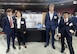 Northeastern University students Alexander Patten, Erica Lu, Logan Kane, and Johan Cho stand by their project display during their senior Capstone Day at Matthews Arena April 15, 2025. The team celebrated the culmination of a yearlong partnership with engineers from the Army Combat Capabilities Development Command (DEVCOM and Personnel Airdrop Systems team in developing modernized equipment used during parachute quality assurance inspections. (Photo courtesy of Natick Soldier Systems Center)