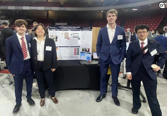 Northeastern University students Alexander Patten, Erica Lu, Logan Kane, and Johan Cho stand by their project display during their senior Capstone Day at Matthews Arena April 15, 2025. The team celebrated the culmination of a yearlong partnership with engineers from the Army Combat Capabilities Development Command (DEVCOM and Personnel Airdrop Systems team in developing modernized equipment used during parachute quality assurance inspections. (Photo courtesy of Natick Soldier Systems Center)