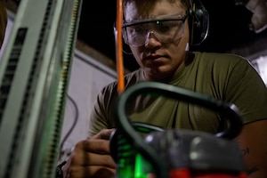 U.S. Air Force Senior Airman John Sturm, 379th Expeditionary Civil Engineer Squadron pavement and equipment operator, watches a gauge during bolt removal within the U.S. Central Command area of responsibility, May 26, 2025. Heavy equipment operators are responsible for maintaining and inspecting concrete and asphalt runways, aircraft parking aprons and other airfield surfaces to ensure readiness. (U.S. Air Force photo by Senior Airman Amanda Jett)