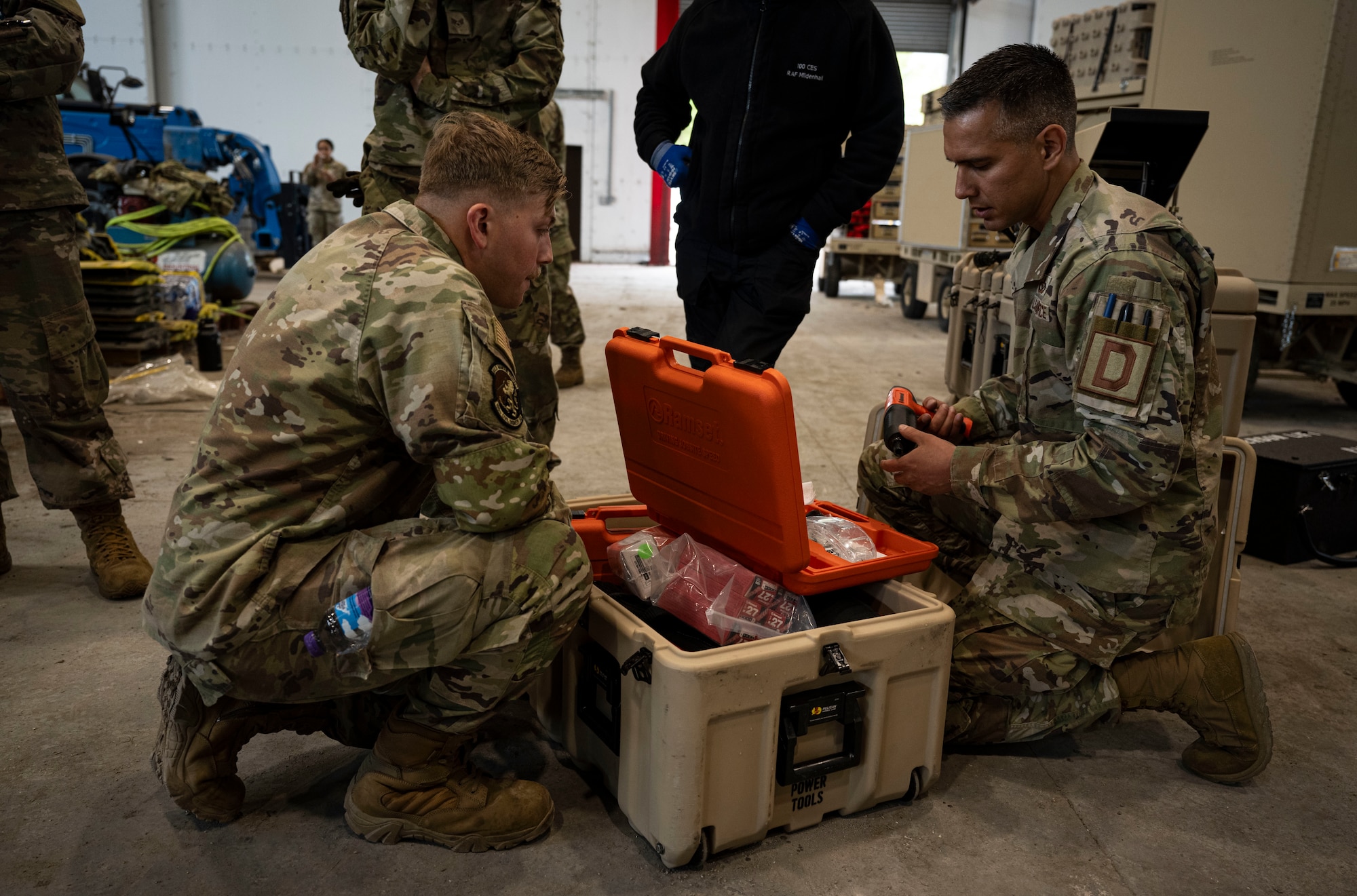 U.S. Air Force Master Sgt. Julio Arteaga, right, 100th Civil Engineer Squadron electrical systems section chief, unloads a toolkit associated with the expeditionary airfield lighting system at RAF Feltwell, England, June 6, 2025.