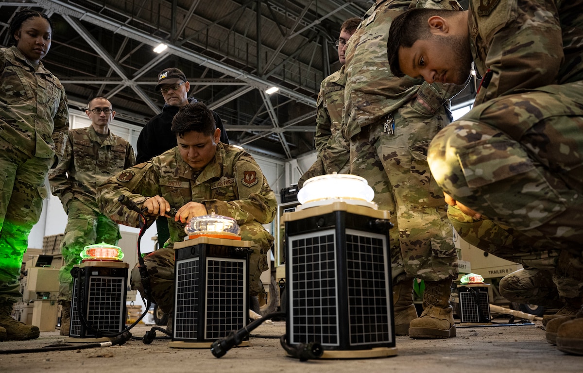U.S. Air Force Airmen assigned to the 100th Civil Engineer Squadron examine a newly configured set of solar-powered airfield lights during an expeditionary airfield lighting system familiarization class at RAF Feltwell, England, June 6, 2025.