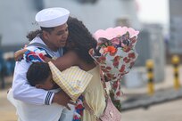 Culinary Specialist 1st Class Henry Ramos, assigned to the Arleigh Burke-class guided-missile destroyer USS Oscar Austin (DDG 79), gives the first hug during the ship’s return to Naval Station Rota, Spain, June 10, 2025.