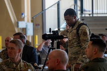 Senior Airman Trust Tate, 5th Bomb Wing public affairs specialist, captures video of a speaker during a Military Affairs Committee (MAC) luncheon at Minot Air Force Base, North Dakota, June 5, 2025. Hosted regularly by both the Minot Area Chamber Economic Development Corporation (EDC) and Minot AFB, the MAC lunch provides a platform for civic leaders and military personnel to connect, exchange ideas, and stay informed about the base’s mission and activities. (U.S. Air Force photo by Senior Airman Alex Nottingham)