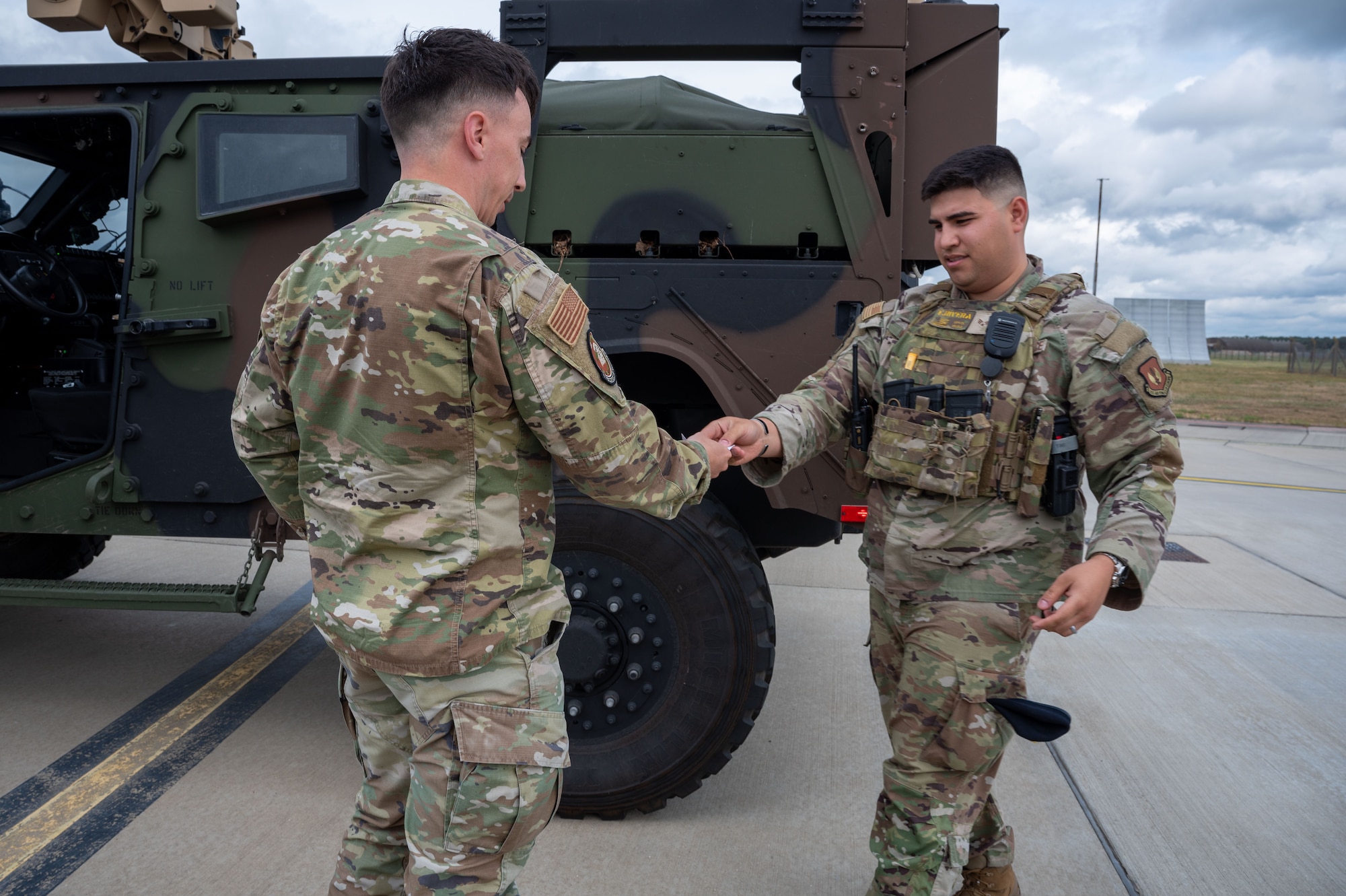 Two service members exchange a piece of paper