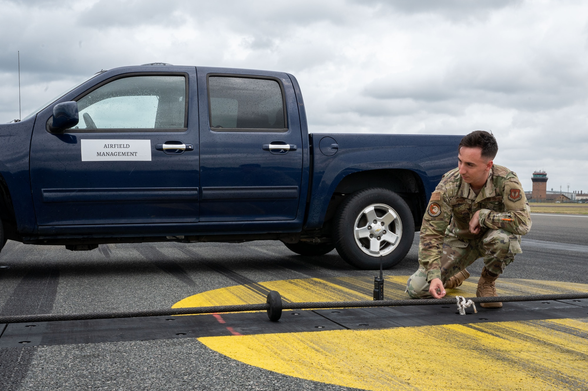 A service member checks a barrier cable on the flightline