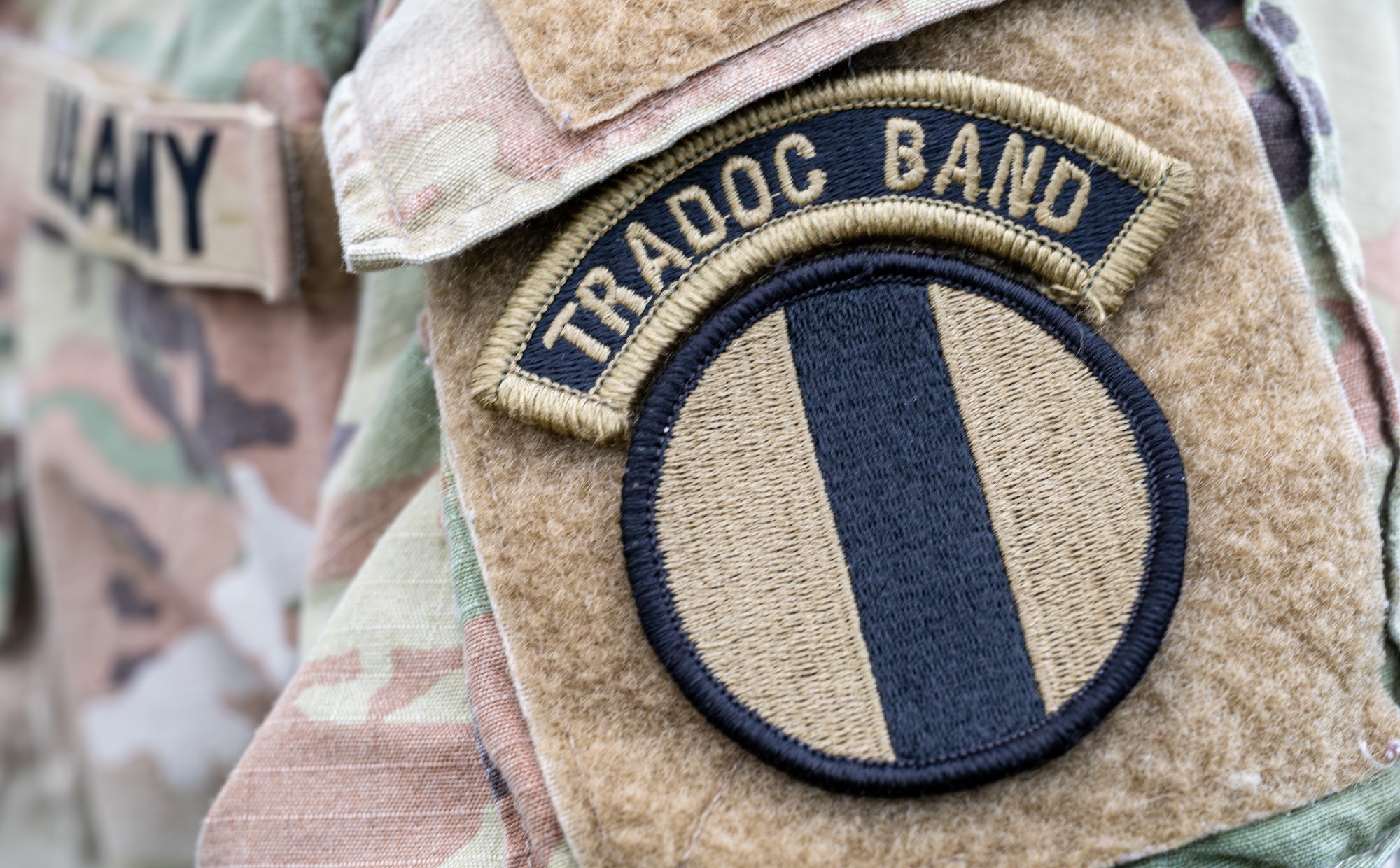 A U.S. Army Soldier assigned to the Training Doctrine and Command Band showcases his patch.