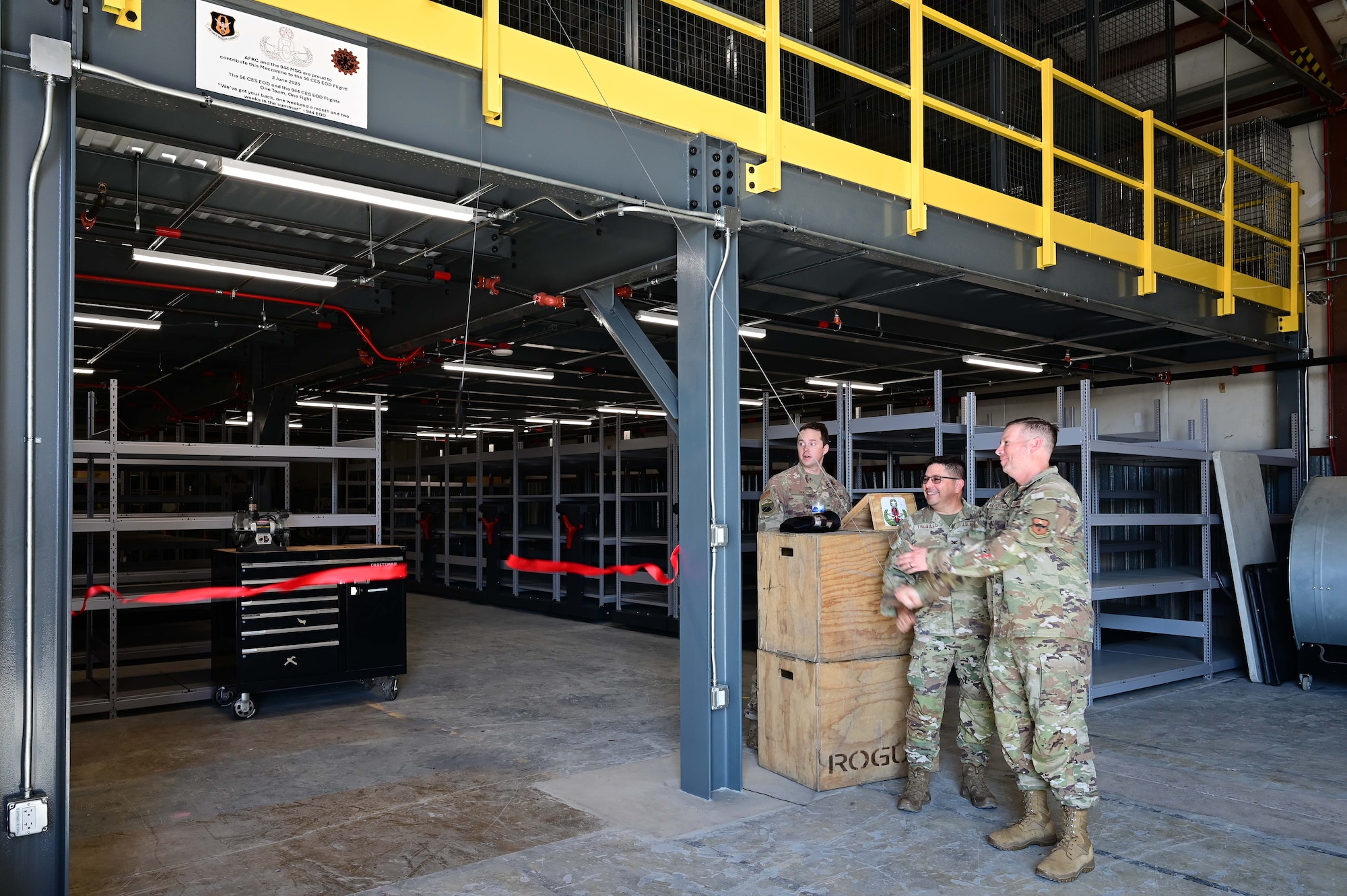Col. Reginald Trujillo, 944th Mission Support Group commander
 and Col. Peter Abercrombie, 56th MSG commander, cut the ribbon on the new Explosive Ordnance Disposal mezzanine, at Luke Air Force Base, Ariz., June 3, 2025. The previous infrastructure was unsafe for equipment storage and Airmen movements. (U.S. Air Force Photo by MSgt Courtney Richardson)
