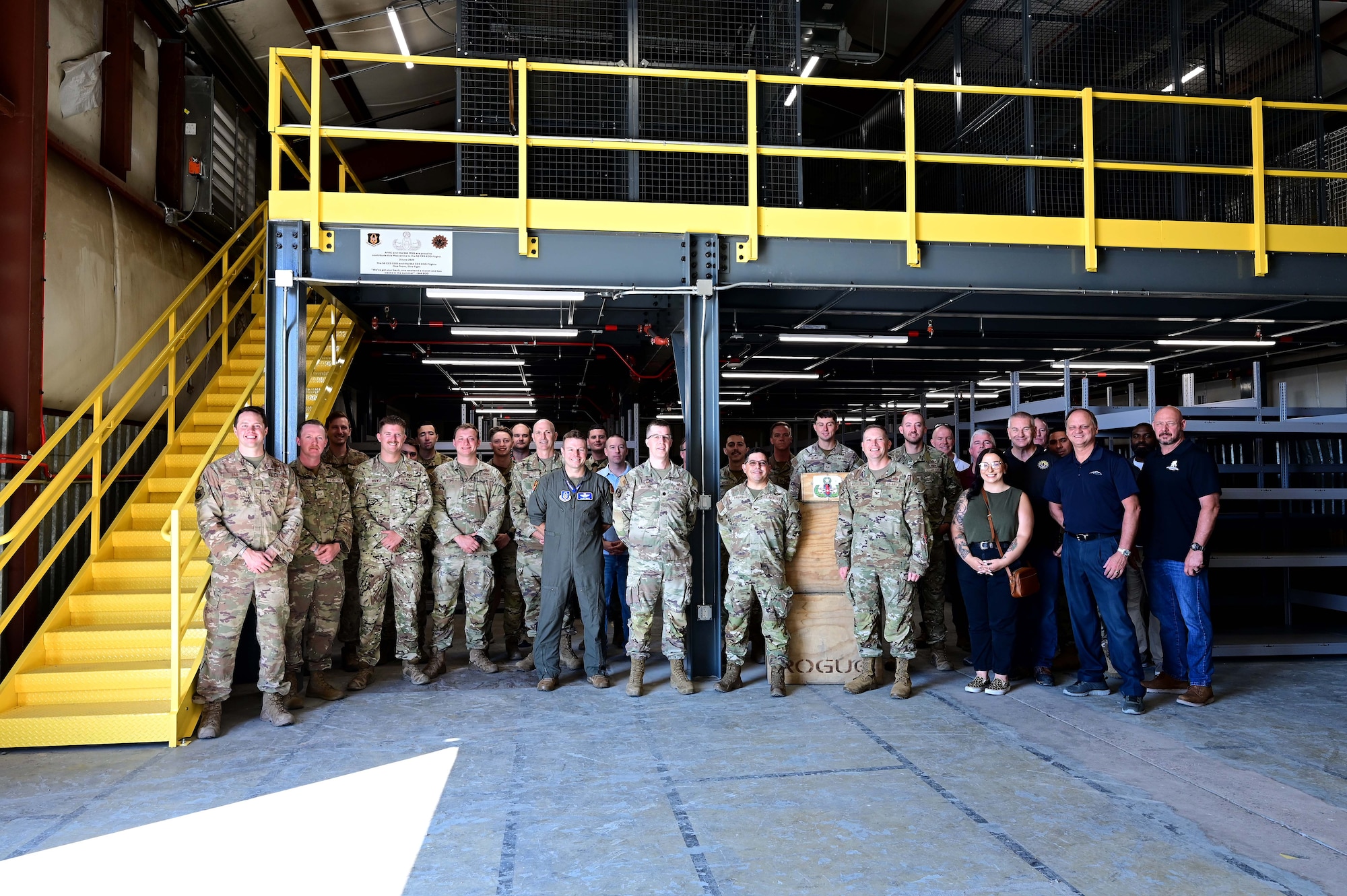 Explosive Ordnance Disposal Airmen from the 56th and 944th Fighter Wing pose for a group photo underneath their new mezzanine after the EOD Ribbon Cutting Ceremony at Luke Air Force Base, Ariz., June 3, 2025. The new space will support millions of dollars in deployable equipment. (U.S. Air Force Photo by MSgt Courtney Richardson)