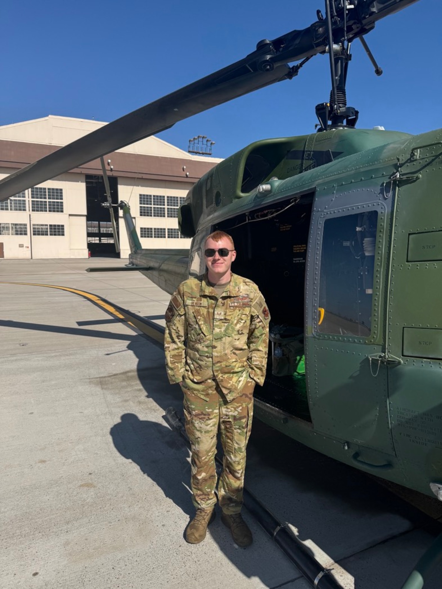 SSgt Benson poses with a Huey