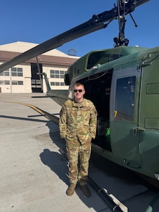 SSgt Benson poses with a Huey