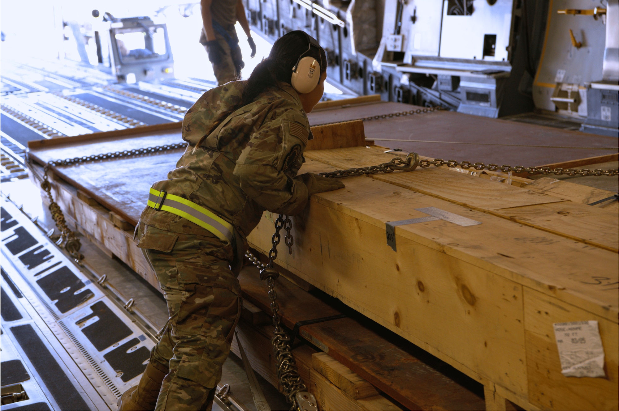 Aerial port specialist, A1C Natalia Larroza, with the 73rd Aerial Port Squadron, secures cargo chains during a live load training operation aboard a C-17 Globemaster III at Travis Air Force Base, Calif., April 14, 2025. The two-week training tour allows Airmen to complete core tasks in preparation for future deployment cycles.