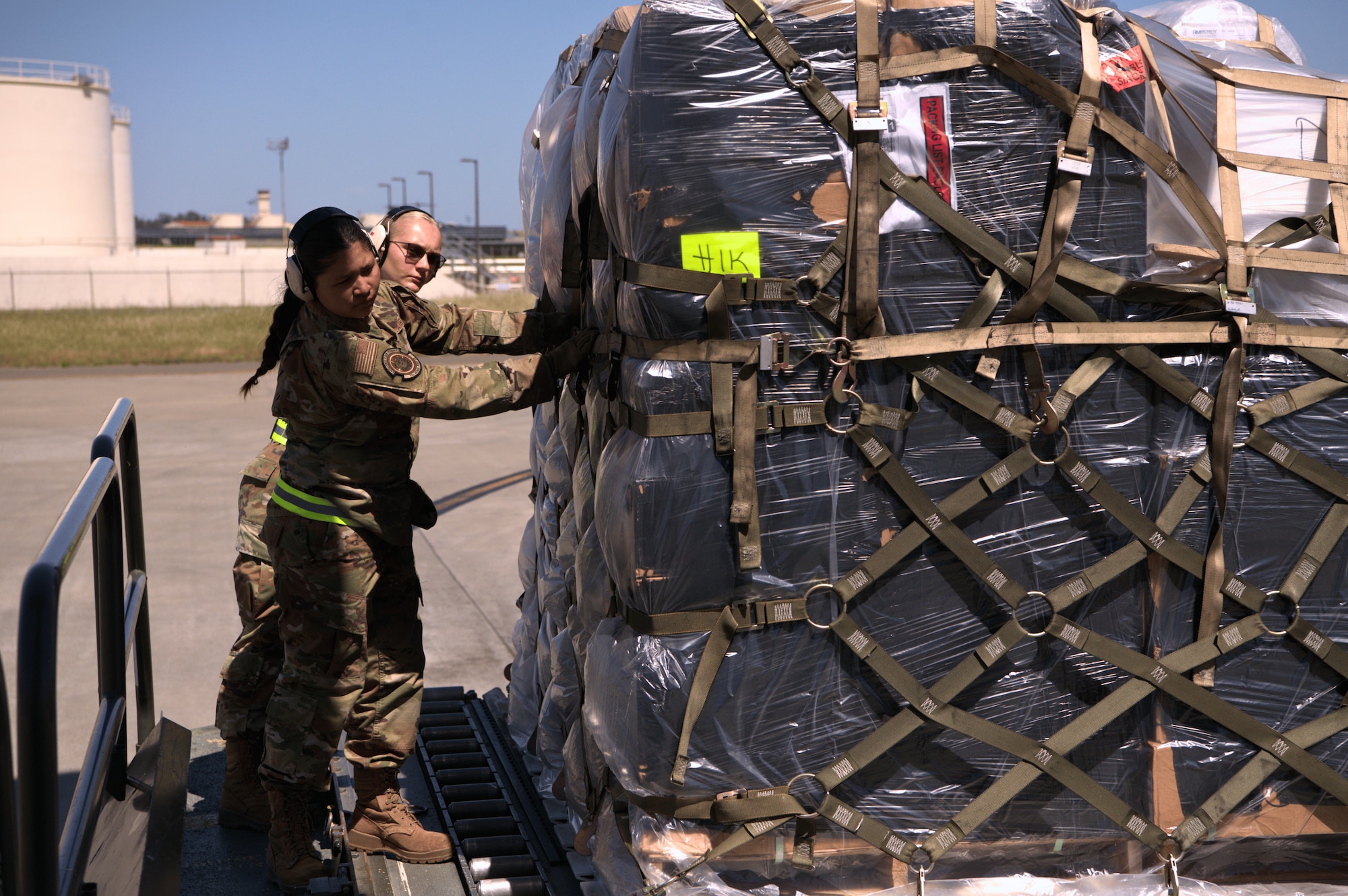 73rd Aerial Port Squadron Airmen, AMN Danielle Cook and A1C Natalia Larroza, push a palletized cargo load into place aboard a C-17 Globemaster III during annual tour training at Travis Air Force Base, Calif., April 14, 2025. The Reserve squadron partnered with the active-duty 60th Aerial Port Squadron to gain hands-on experience with cargo operations.