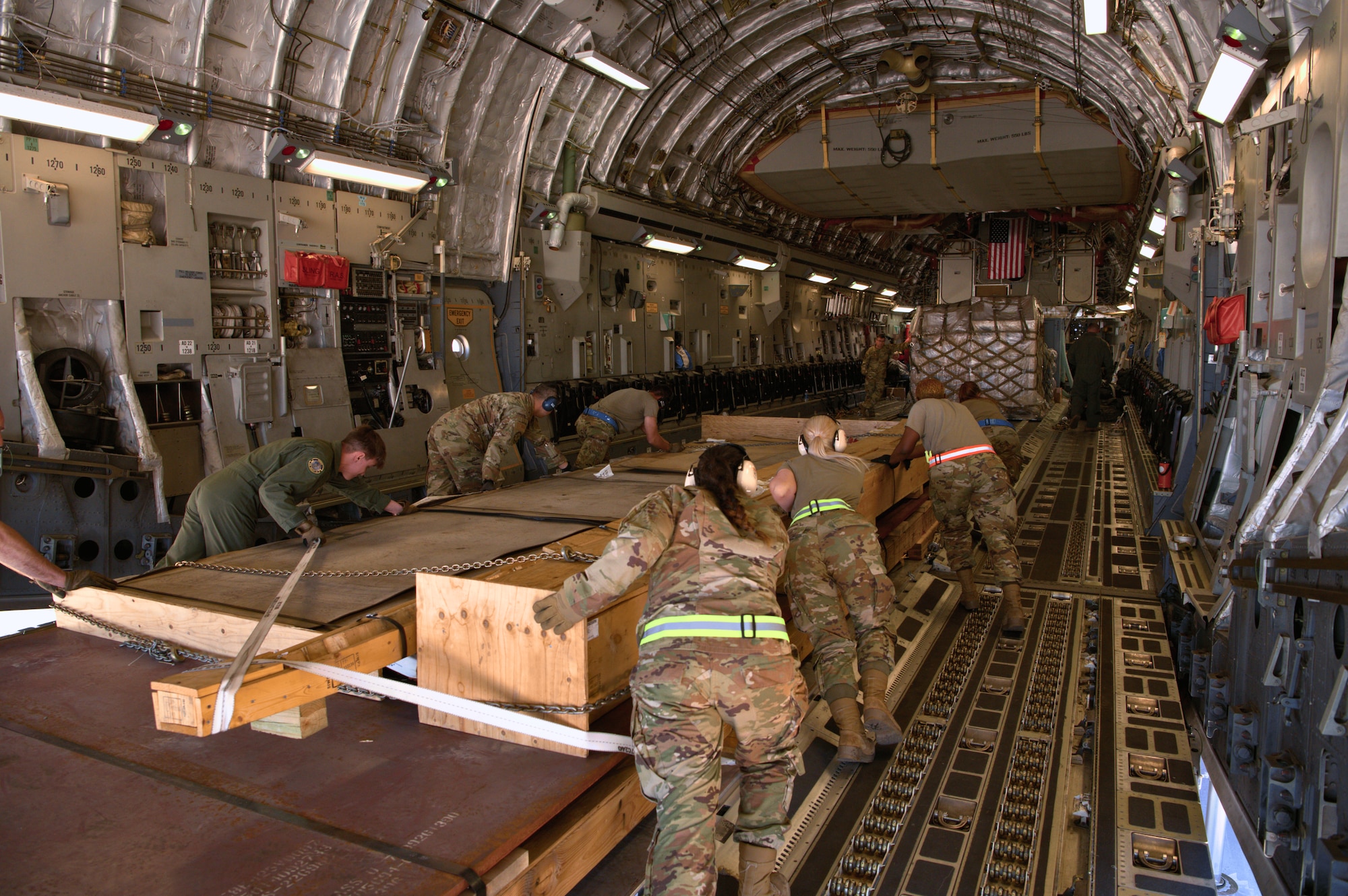Airmen from the 73rd Aerial Port Squadron and 60th Aerial Port Squadron push a palletized cargo load into place aboard a C-17 Globemaster III during annual tour training at Travis Air Force Base, Calif., April 14, 2025. The 73rd APS, based at NAS JRB Fort Worth, Texas, sent 15 Airmen to Travis to integrate with the active-duty 60th APS for two weeks of immersive training.