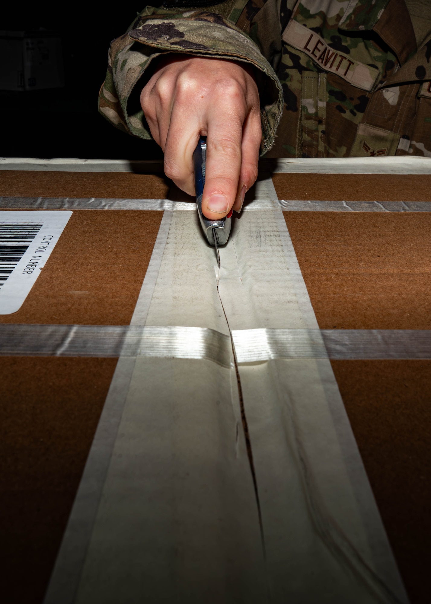 Airman 1st Class Emily Leavitt, Traffic Management Office inbound cargo technician, opens a piece of cargo at Minot Air Force Base, North Dakota, Jun 3, 2025. The Traffic Management Operations team is responsible for coordinating the shipment of cargo, equipment, and personnel to support military operations. (U.S. Air Force Senior Airmen Alex Nottingham)