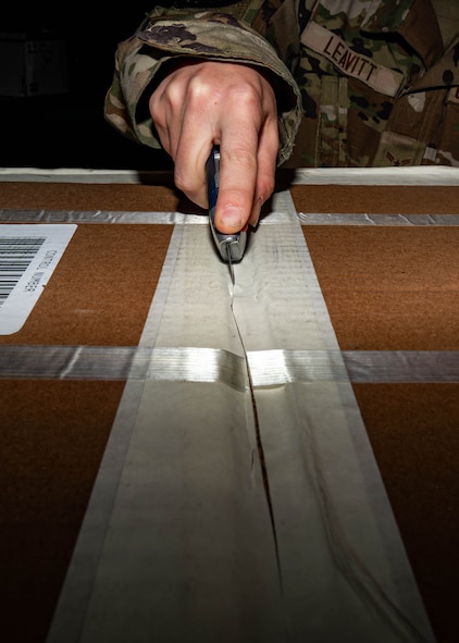 Airman 1st Class Emily Leavitt, Traffic Management Office inbound cargo technician, opens a piece of cargo at Minot Air Force Base, North Dakota, Jun 3, 2025. The Traffic Management Operations team is responsible for coordinating the shipment of cargo, equipment, and personnel to support military operations. (U.S. Air Force Senior Airmen Alex Nottingham)