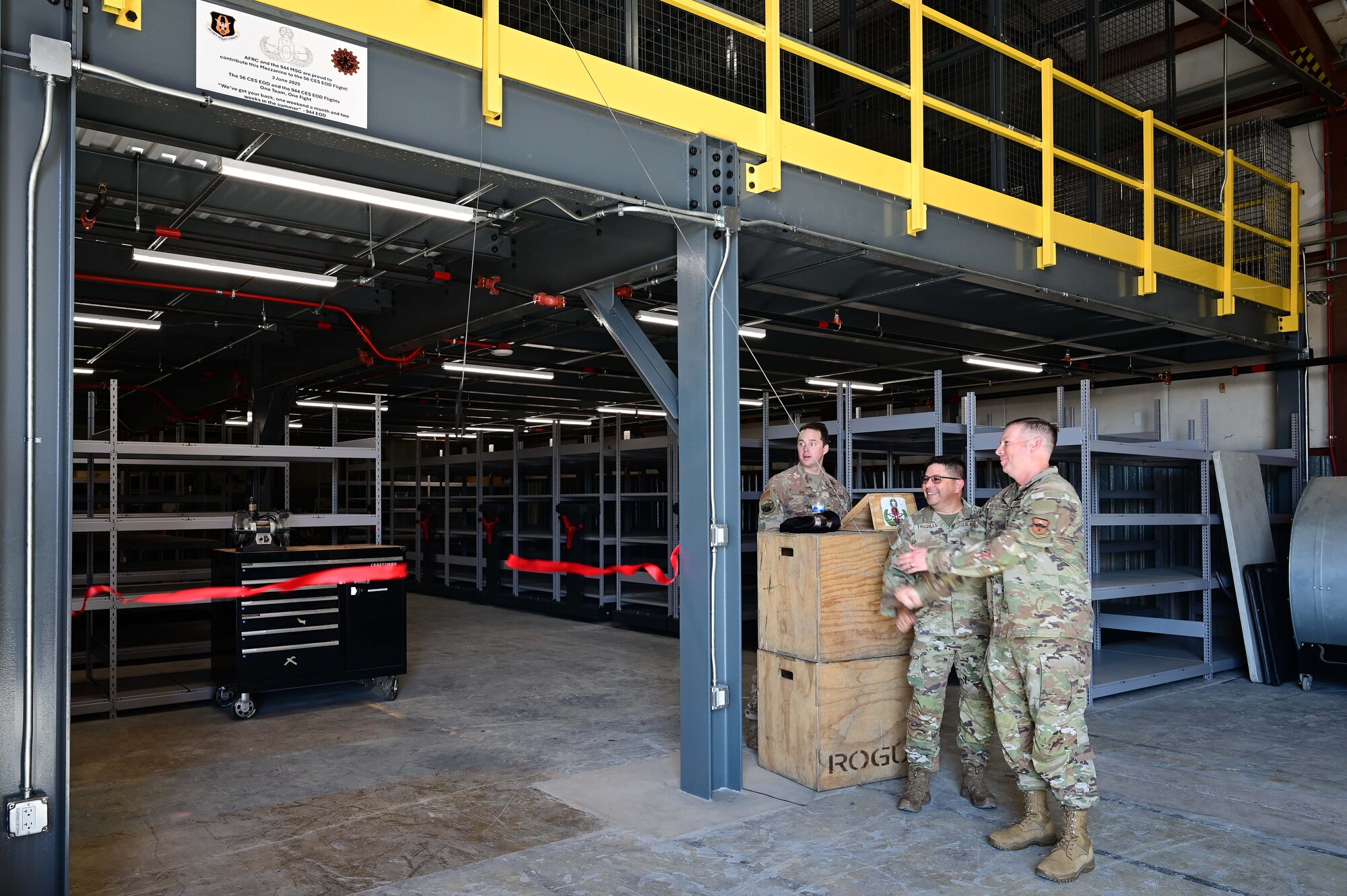 Col. Reginald Trujillo, 944th Mission Support Group commander
 and Col. Peter Abercrombie, 56th MSG commander, cut the ribbon on the new Explosive Ordnance Disposal mezzanine, at Luke Air Force Base, Ariz., June 3, 2025. The previous infrastructure was unsafe for equipment storage and Airmen movements. (U.S. Air Force Photo by MSgt Courtney Richardson)