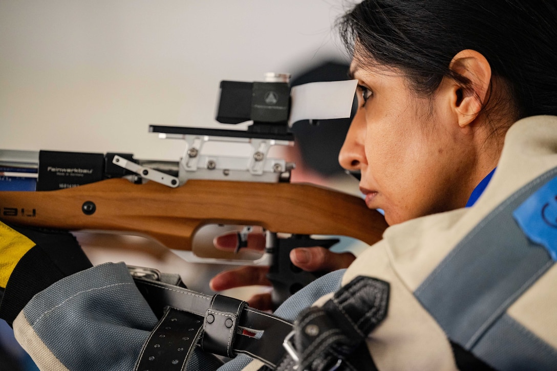 A close-up of the side view of an airman firing a weapon.