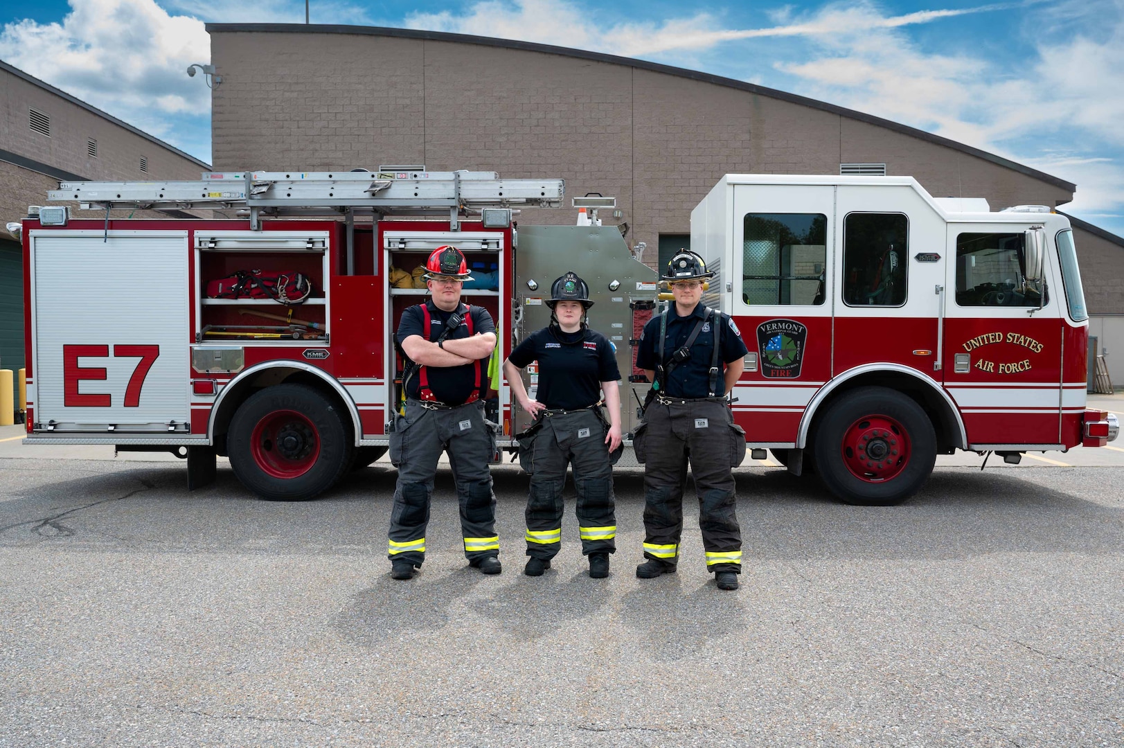 U.S. Air National Guard civilian firefighters, assigned to the Vermont Air National Guard Fire Department, pose in front of the fire truck that was the first on scene.