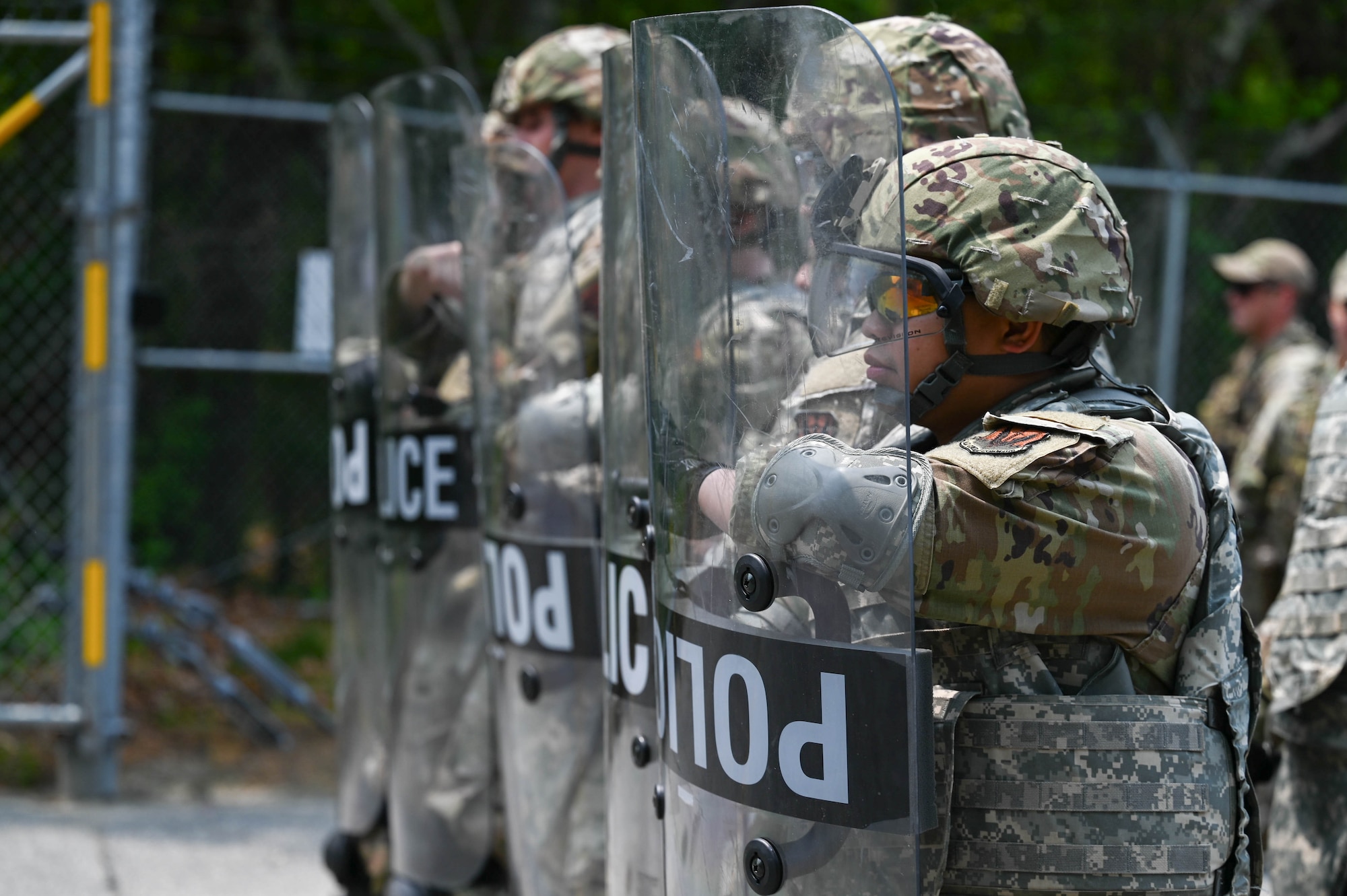 Airmen hold riot control shields.