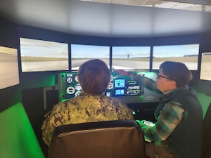An instructor and student use the Hanscom Aero Club's flight simulator.