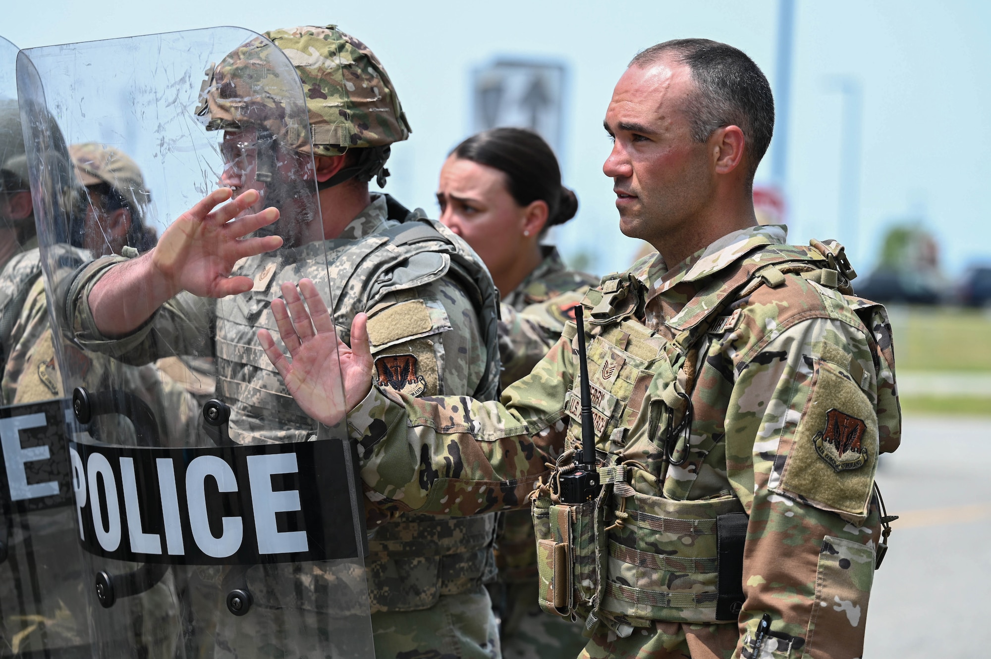 Airmen hold riot control shields.