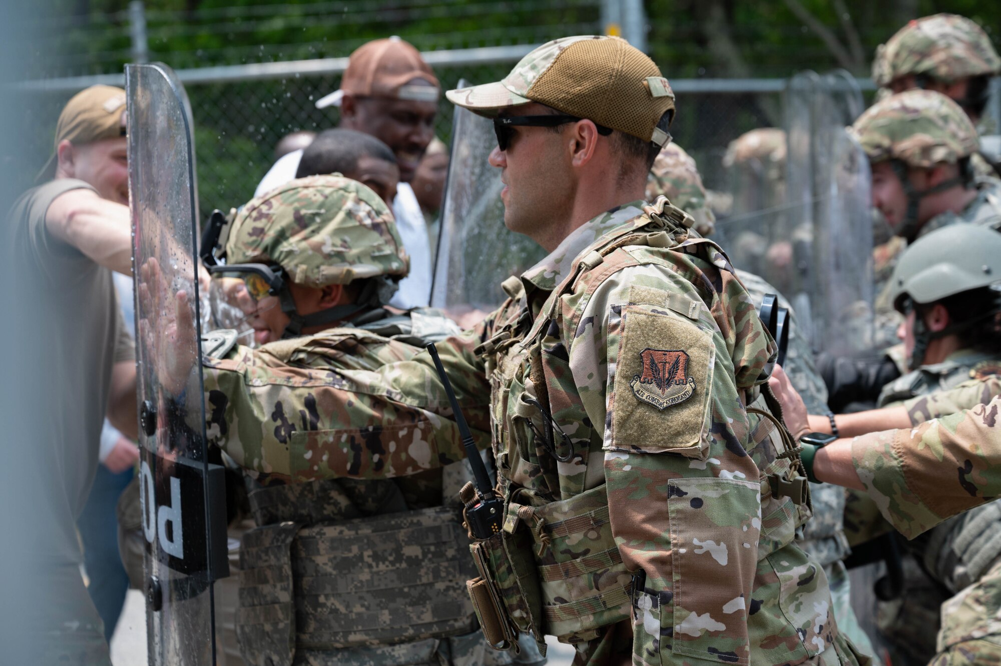 Airmen hold riot control shields.