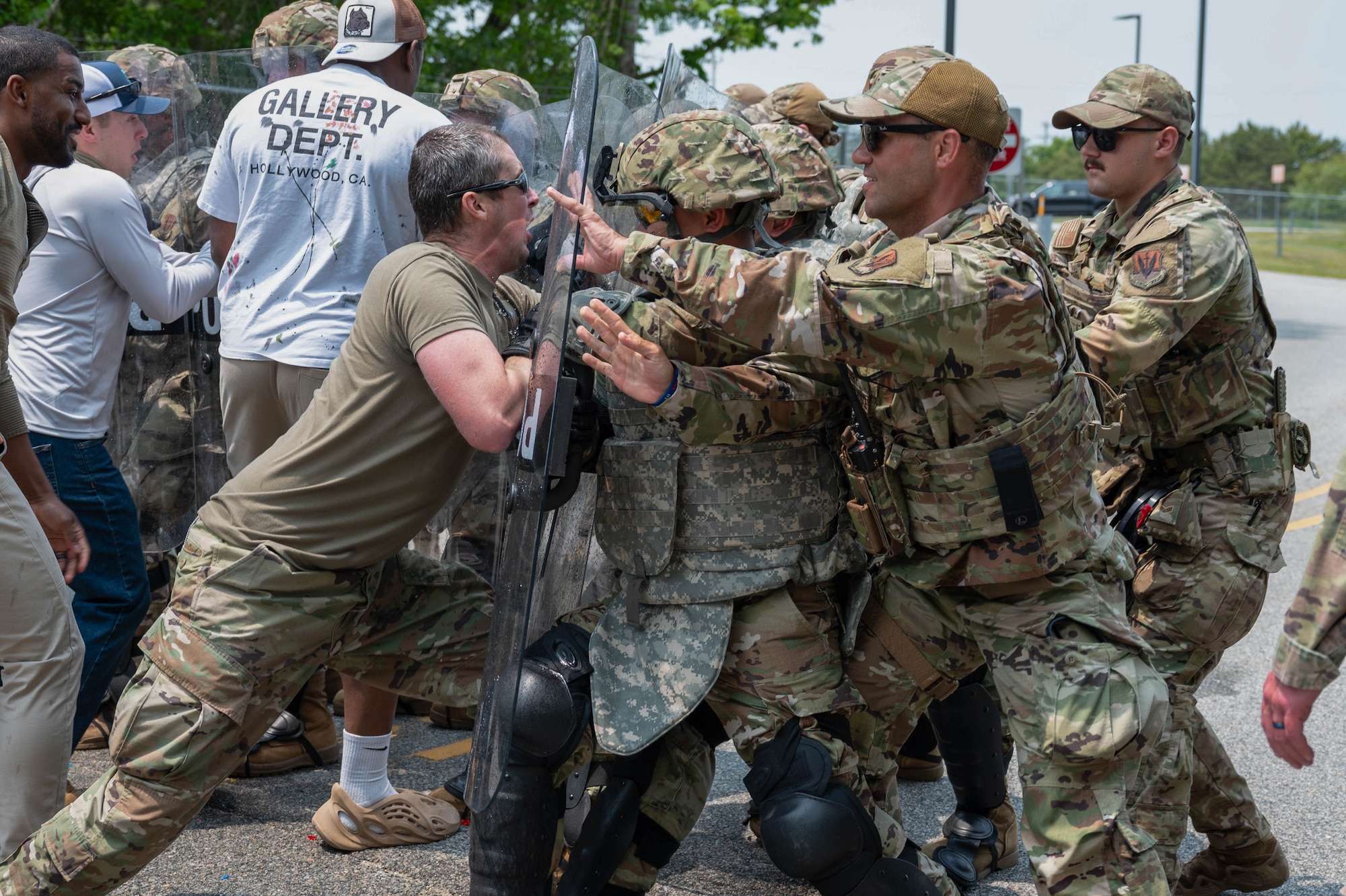 Airmen hold riot control shields.