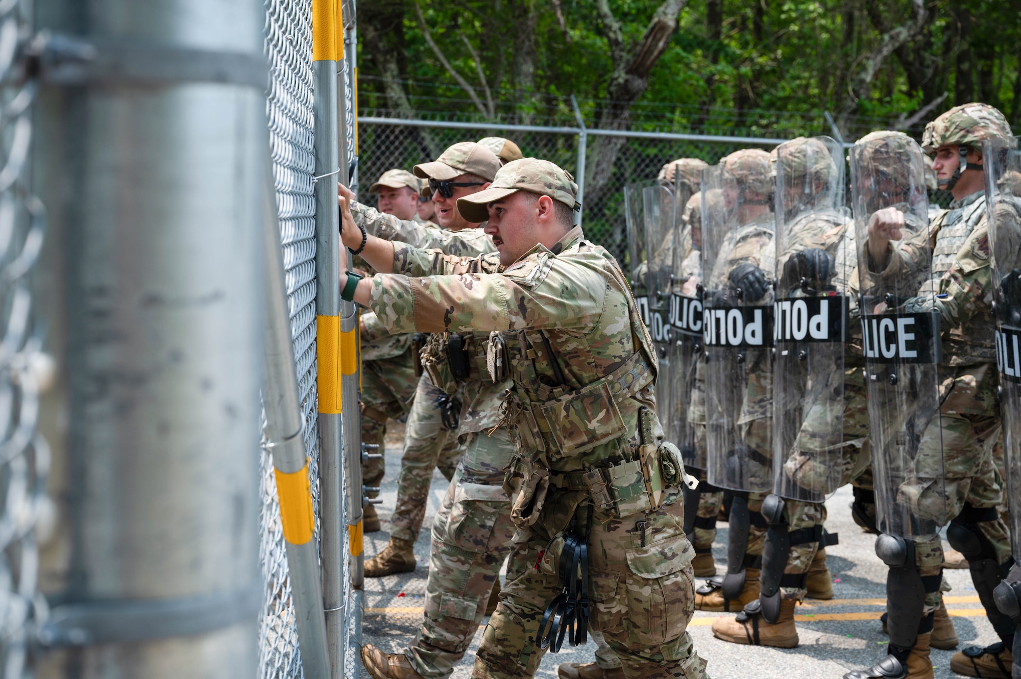 Airmen hold riot control shields.