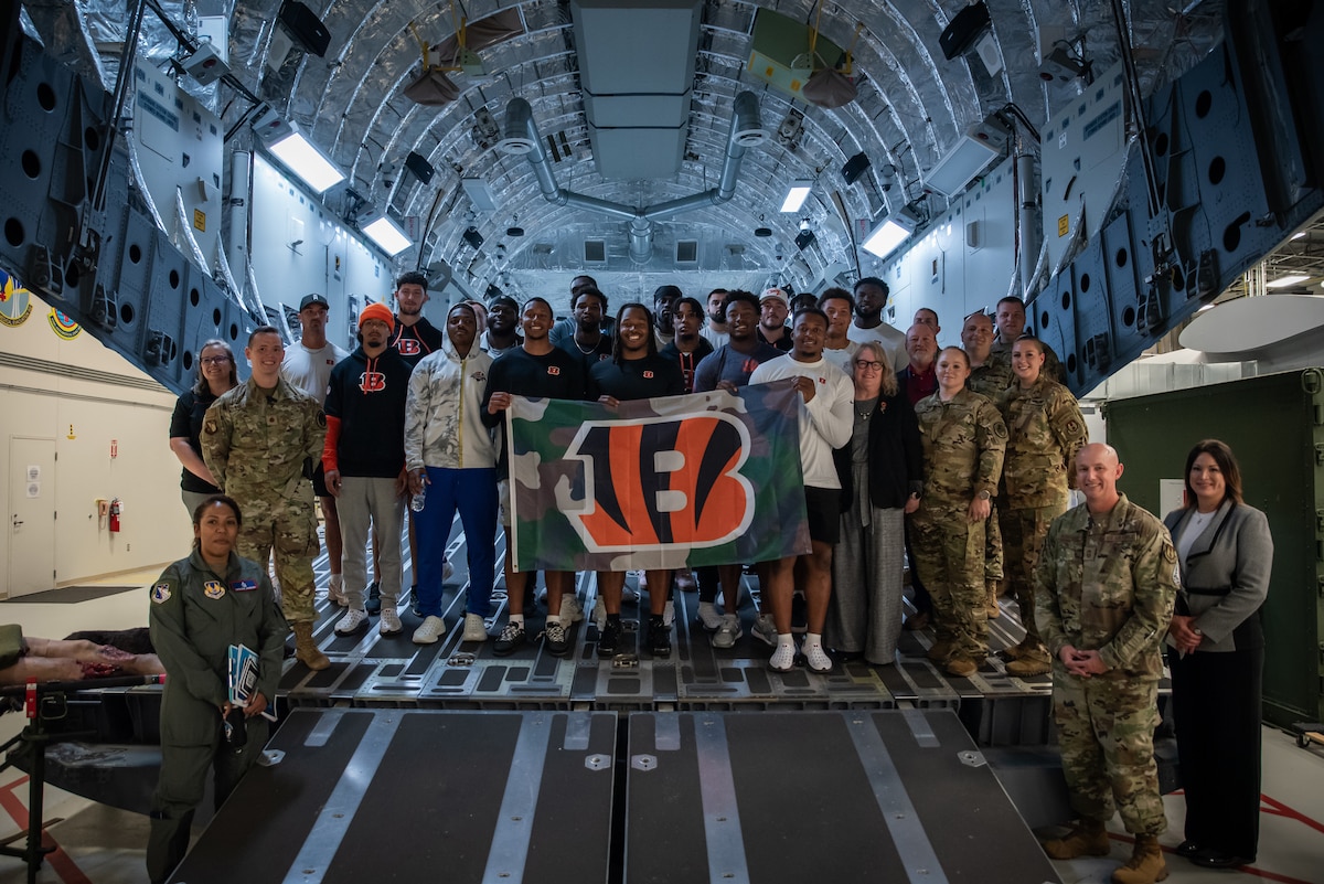 Cincinnati Bengals rookies and military members from Wright-Patterson Air Force Base pose for a group photo inside the C-17 training simulator at the U.S. Air Force School of Aerospace Medicine, Ohio, June 6, 2025. The rookies visited Wright-Patt to engage with Airmen, Guardians and their families during a day that included tours of human performance labs, briefings on military working dogs and a skills clinic for military children. (U.S. Air Force photo / Richard Eldridge)