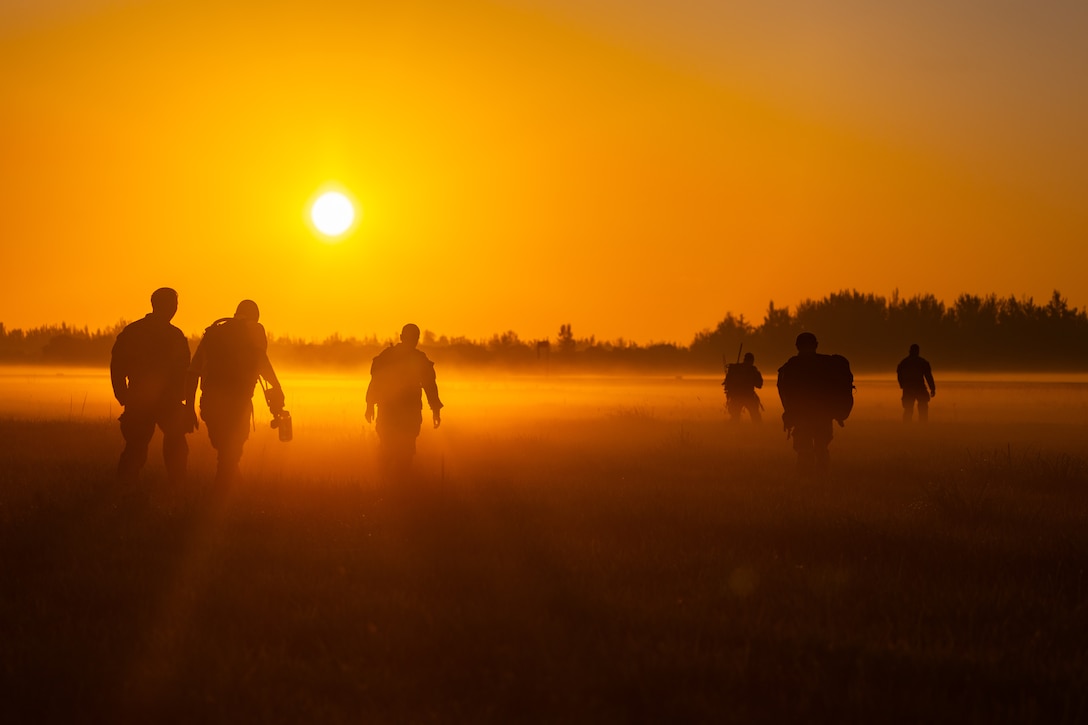 In the early morning hours, U.S. Army soldiers assigned to the 478th Civil Affairs Battalion, and paratroopers assigned to the British 4th Battalion, walk across a field, heading back to an awaiting vehicle after conducting a jump and land operations during Lagoon Leap 2025, at Homestead Air Base, Fla., May 14-16th, 2025.(U.S. Army photo by Staff Sgt. Tarako Braswell)