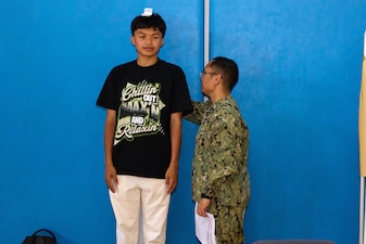 250529-N-FT324-7655. ROTA, Spain. May 29, 2025. Hospitalman Rigel Villaruel, Corpsman, U.S. Naval Hospital Rota Medical Homeport, takes measurements of a student during the annual sports physical fair at the school. The event ensures students are healthy and ready to participate in sports for the upcoming year, highlighting the strength of partnership and outreach with local community schools. (U.S. Navy Photo by Mr. Everett Lopez/ Released by Lt. Cmdr. Alicia Sacks)