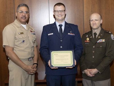 U.S. Navy Capt. Juan Rosario (left), Chief of Staff at Walter Reed National Military Medical Center, and U.S. Army Lt. Col. Michael Orestes (right), Director for Education, Training and Research at Walter Reed, recognize U.S. Air Force (Dr.) Capt. Kiffin Smallegan, of the Department of Pediatrics, for earning first place in the Department of Research Programs' annual poster competition in the evidence-based practice category. The annual competition highlights research conducted by Walter Reed's staff, interns, residents and fellows.