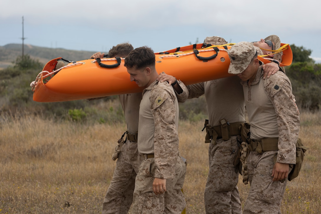 U.S. Marines and Sailors with 3rd Battalion, 1st Marines, 1st Marine Division, carry a SKED device with a simulated casualty during an air raid course hosted by the Amphibious Raids Branch, Expeditionary Operations Training Group, I Marine Expeditionary Force, at Marine Corps Base Camp Pendleton, California, June 2, 2025.