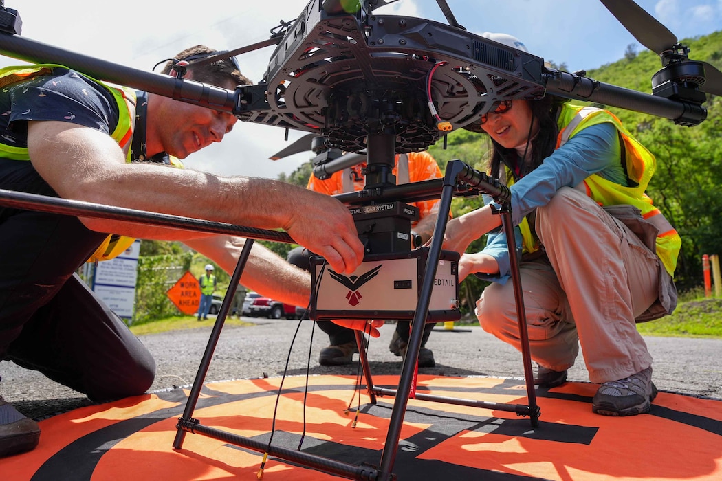 Drone operators prepare a heavy lift drone for flight at the Red Hill Bulk Fuel Storage Facility (RHBFSF) in Honolulu, May 16, 2025. The drone was fitted with a laser sensor called a LiDAR,  or light detection and ranging, as part of an ongoing joint effort between Navy Closure Task Force-Red Hill (NCTF-RH), the Expeditionary Warfare Center, and Naval Information Warfare Center Atlantic to create a 3D map of the  RHBFSF. Charged with the safe decommissioning of the facility, NCTF-RH was established by the Department of the Navy as a commitment to the community and the environment. NCTF-RH continues to engage with the people of Hawaii, regulatory agencies, and other stakeholders as it safely and deliberately decommissions the RHBFSF. (U.S. Navy photo by Mass Communication Specialist 1st Class Glenn Slaughter)