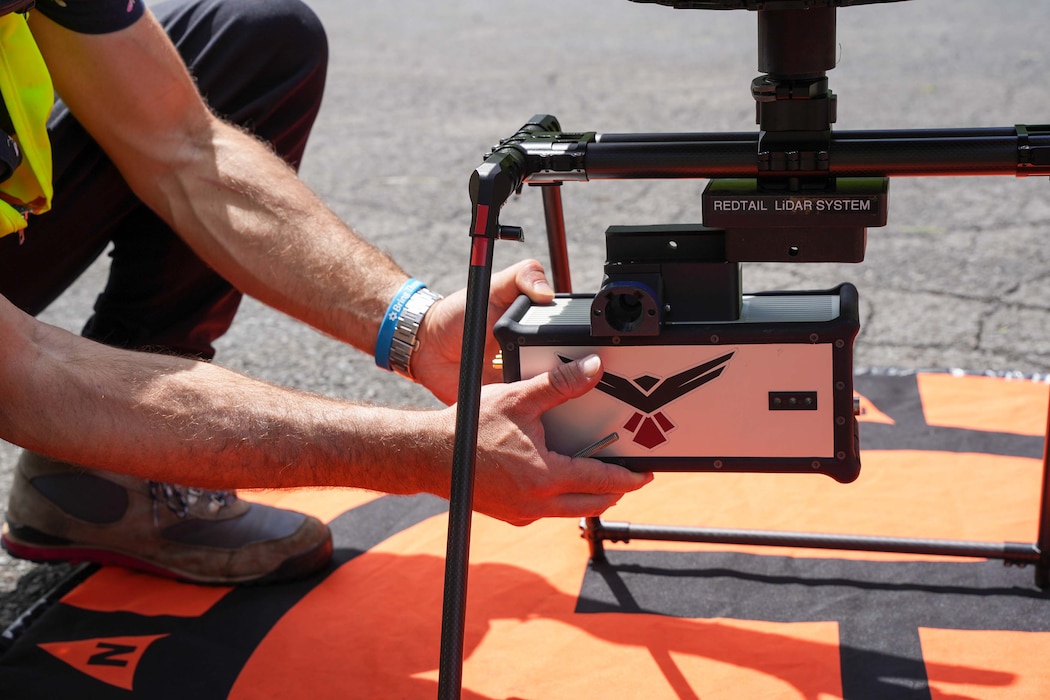 A drone operator connects a laser sensor called a LiDAR, or light detection and ranging, onto a heavy lift drone at the Red Hill Bulk Fuel Storage Facility (RHBFSF) in Honolulu, May 16, 2025. The operation was part of an ongoing joint effort between Navy Closure Task Force-Red Hill (NCTF-RH), the Expeditionary Warfare Center, and Naval Information Warfare Center Atlantic to create a 3D map of the RHBFSF. Charged with the safe decommissioning of the facility, NCTF-RH was established by the Department of the Navy as a commitment to the community and the environment. NCTF-RH continues to engage with the people of Hawaii, regulatory agencies, and other stakeholders as it safely and deliberately decommissions the RHBFSF. (U.S. Navy photo by Mass Communication Specialist 1st Class Glenn Slaughter)