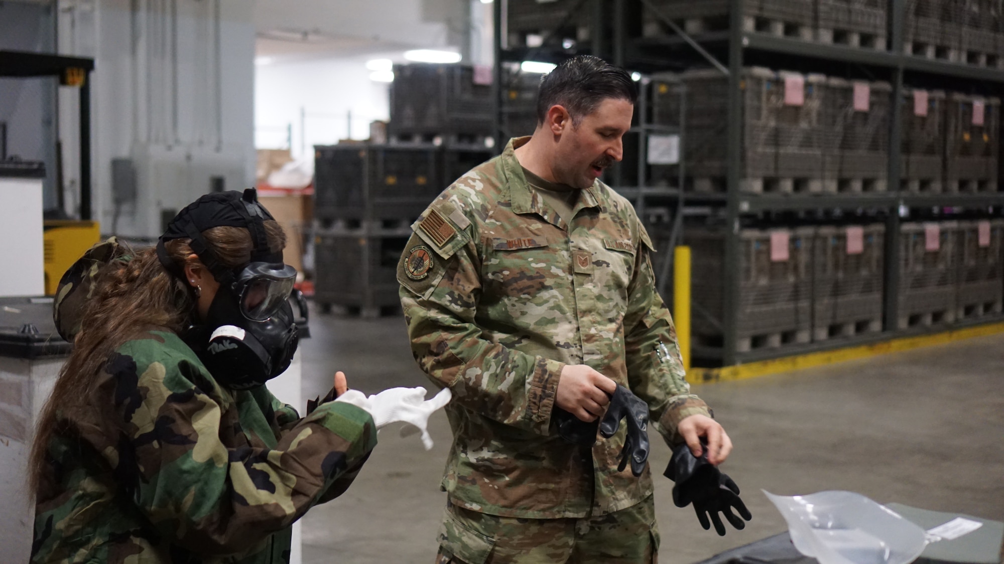 A Junior ROTC cadet tries on individual protective equipment during a tour of an Air Force base.