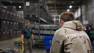 A Junior ROTC cadet tries on individual protective equipment during a visit to the base.